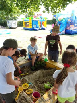 Die Kinder spielen im Sandkasten beim Schulabschlussfest