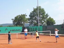 Die Kinder beim Tennis spielen beim Schulabschlussfest der Volksschule